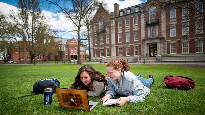 两个学生在看一台笔记本电脑
